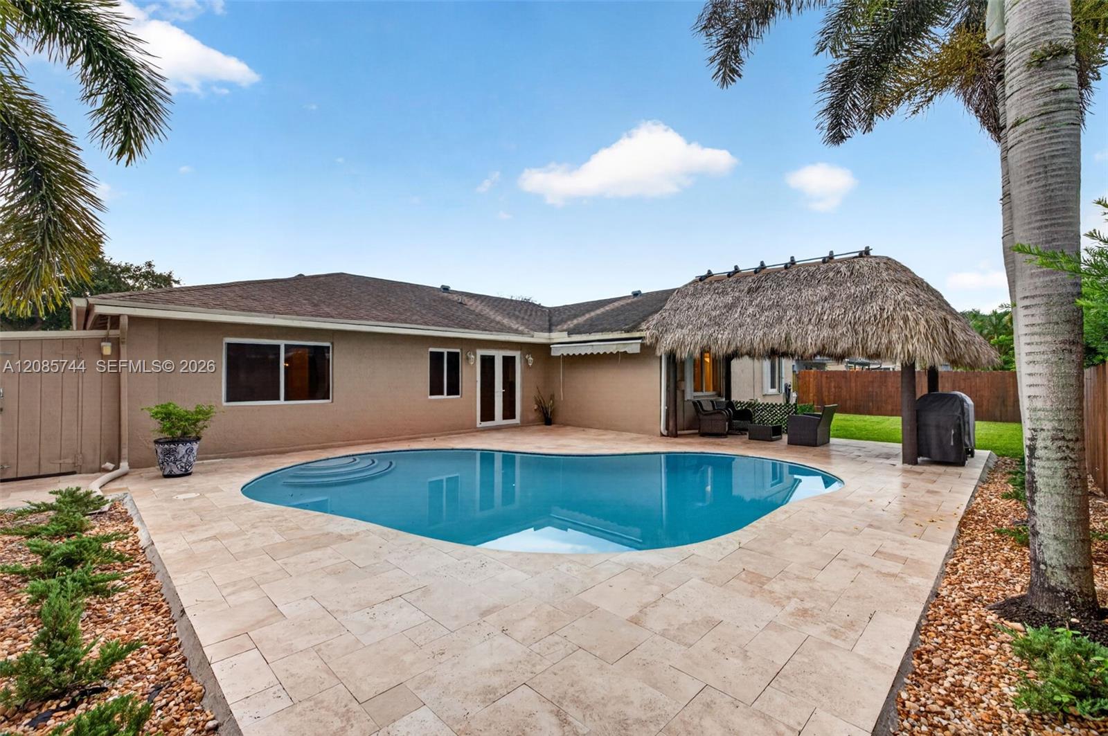 Gorgeous recently resurfaced pool w/ travertine decking, fully fenced, w/ amazing tiki hut, recently rethatched and new sprinkler pump