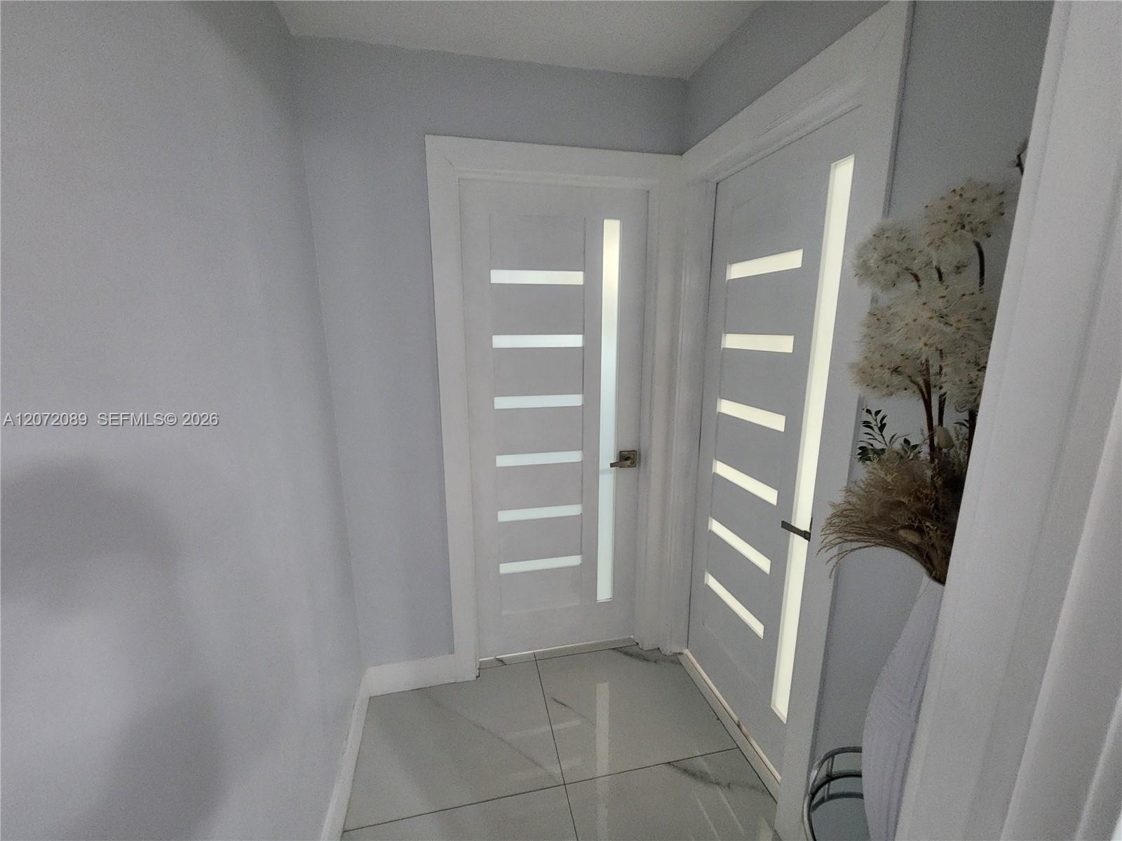 Interior hallway separating bedroom and bathroom from the living area – tile flooring throughout