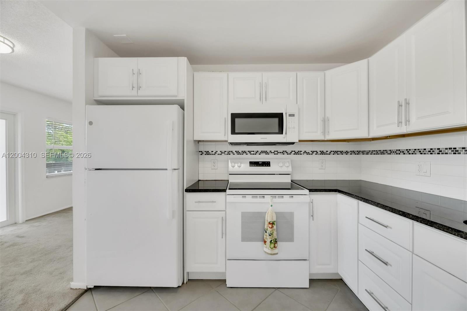Kitchen close-up — refrigerator, range, over-range microwave, cabinetry detail