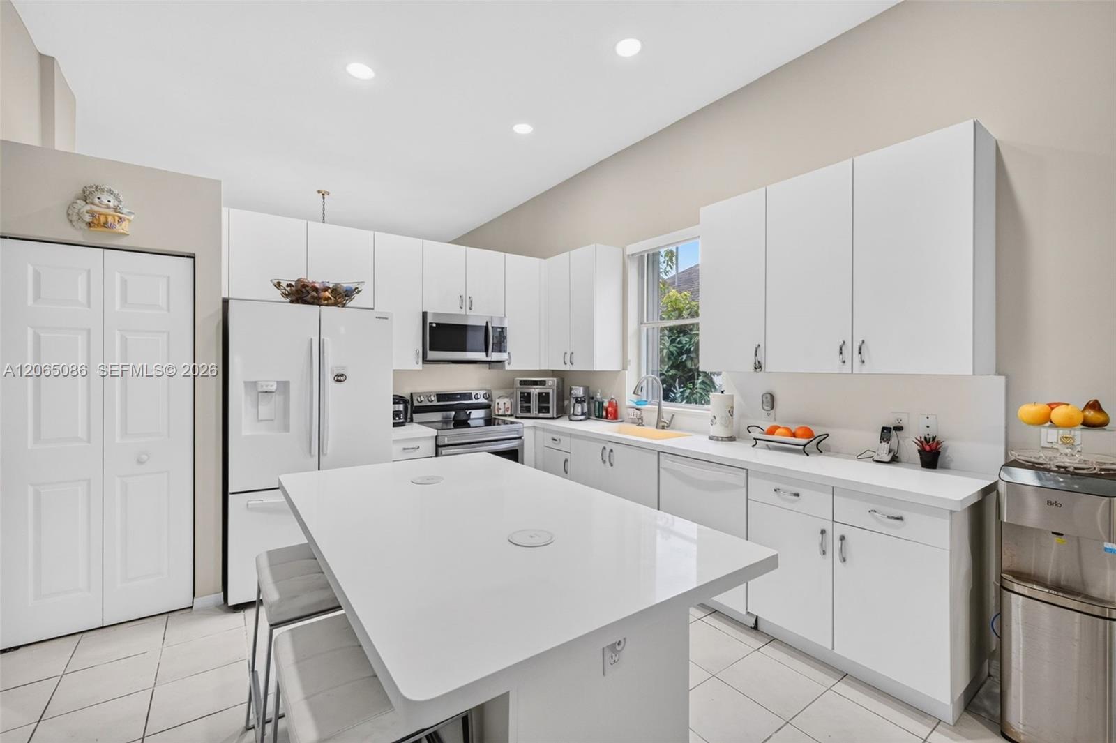 Spacious open concept kitchen w/ built in wall unit, volume ceilings and solid surface counters