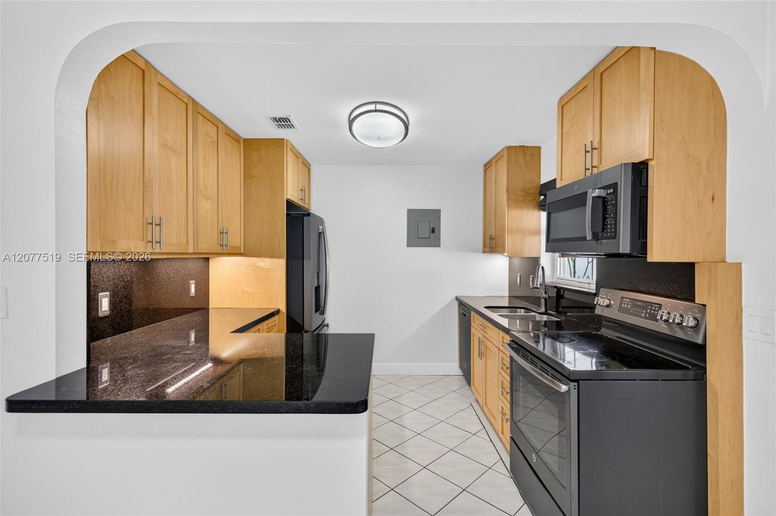 Updated 2017 kitchen featuring birch cabinetry, quartz countertops and GE appliances. Virtually-Staged.