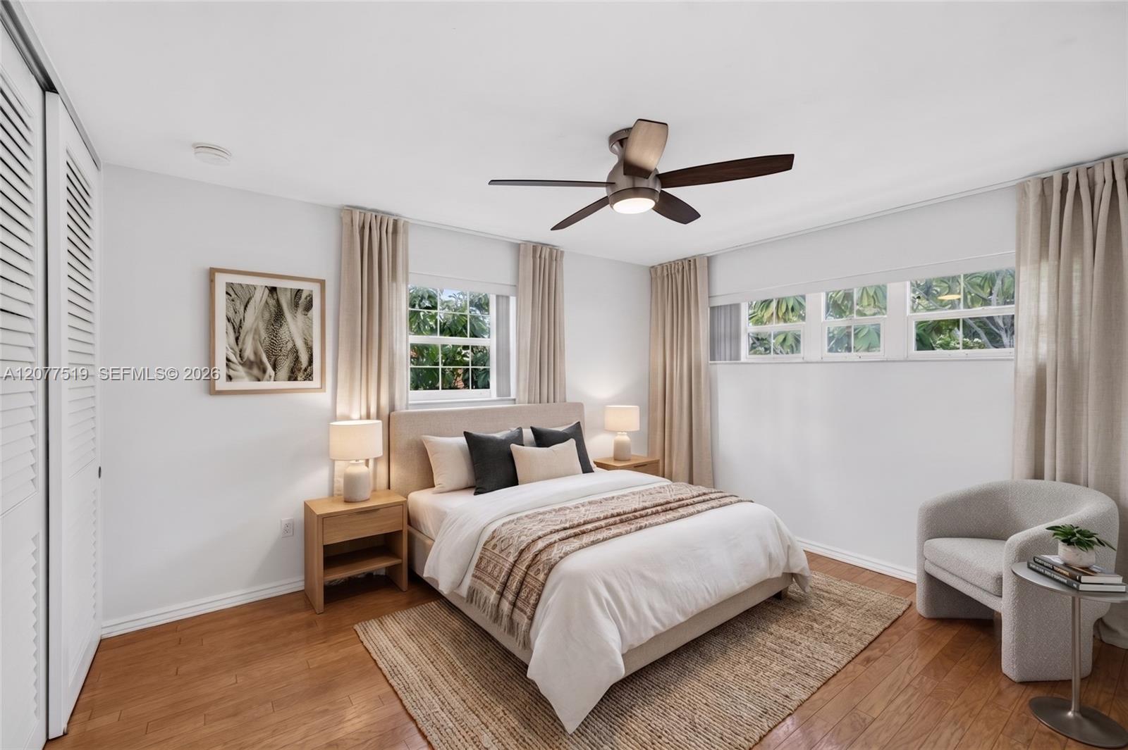 Spacious primary bedroom with updated flooring, blinds and generous closet storage. wood flooring, updated blinds and a walk-in closet. Virtually-Staged.