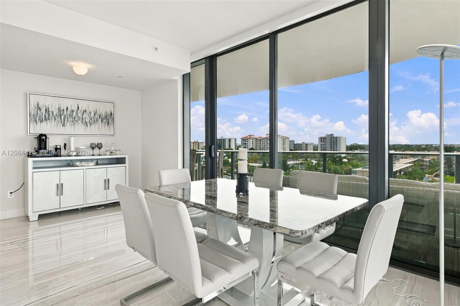 Dining area with floor-to-ceiling windows and direct balcony access.