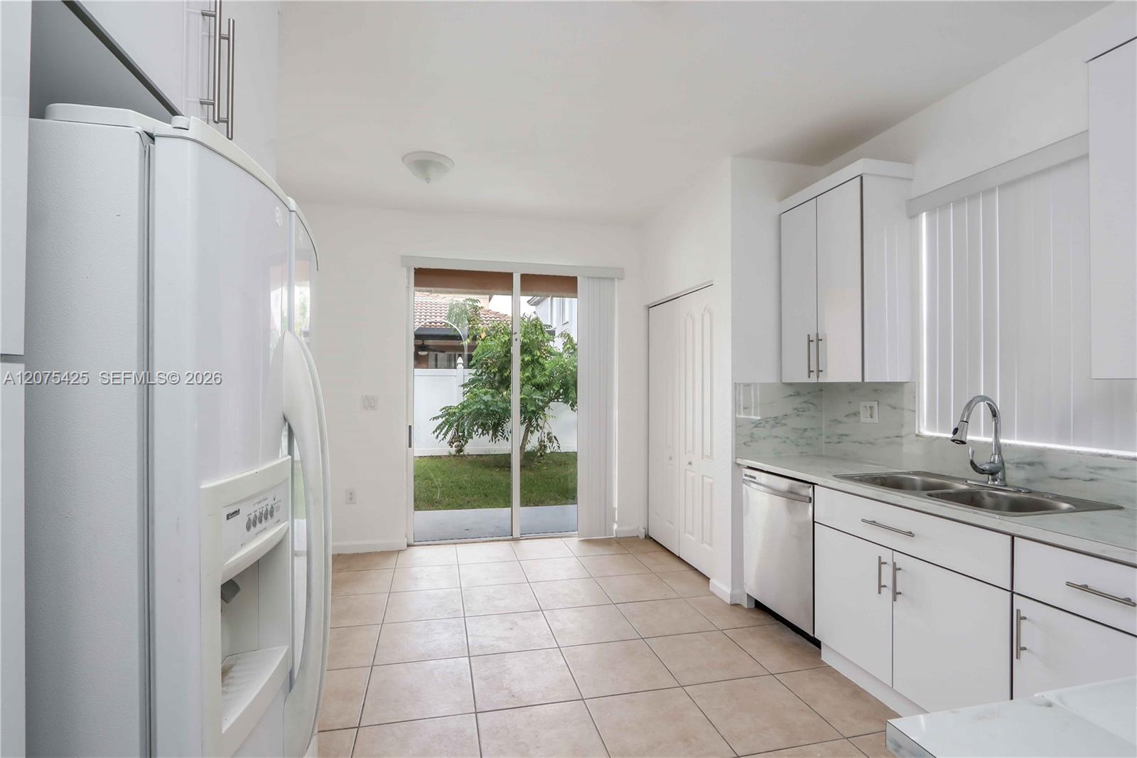 Modern kitchen featuring white cabinetry and appliances.