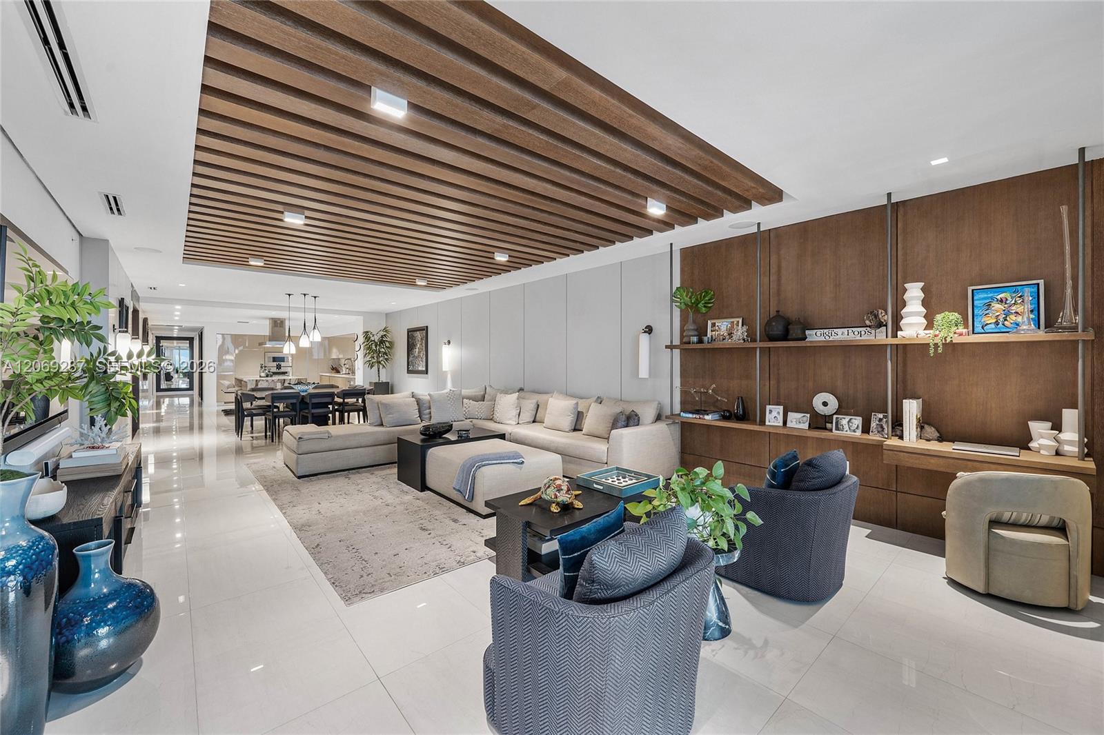 An expansive living room offering panoramic waterfront views and seamless access to the terrace.