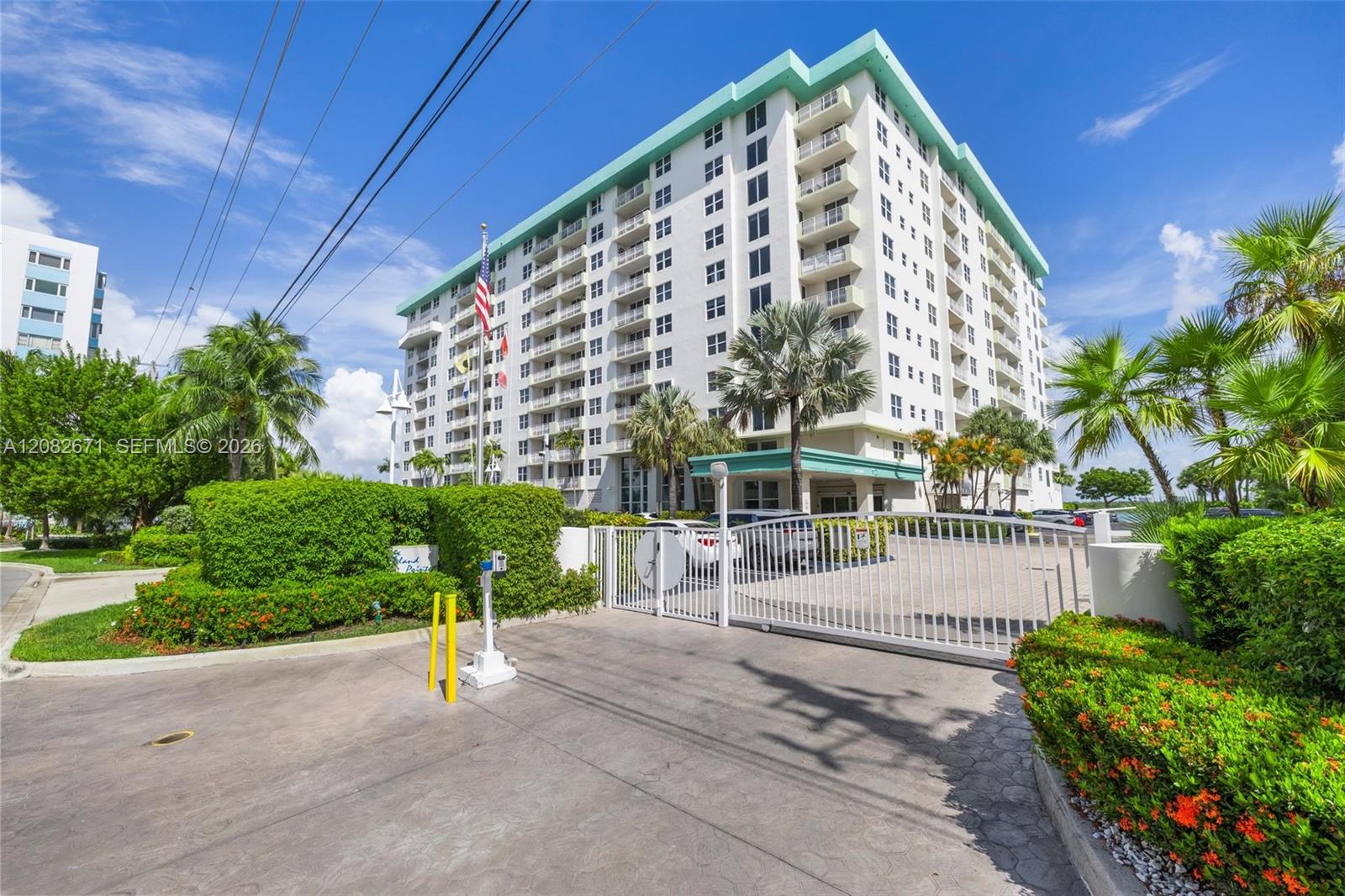 Gated entry to Island Pointe, lushly landscaped with a circular drive.