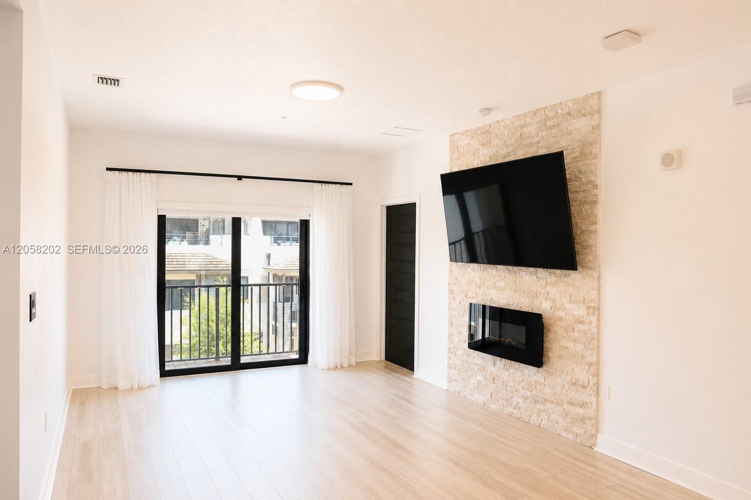 Custom stone accent wall with a built-in electric fireplace and a wall-mounted flat-screen TV