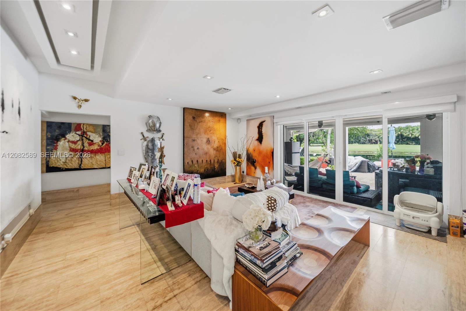 Spacious living area featuring modern recessed lighting, elegant flooring, and large sliding glass doors that provide abundant natural light and views of the outdoor area.
